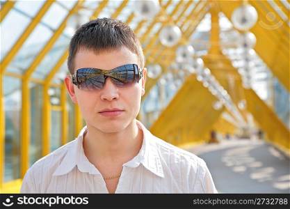young man in sunglasses on footbridge