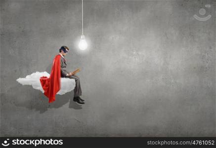 Young man in super hero costume sitting on roof. Bored superhero
