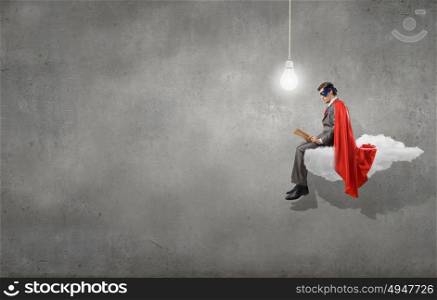 Young man in super hero costume sitting on roof. Bored superhero