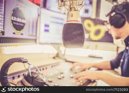Young man in the broadcasting studio, radio, talking into the microphone