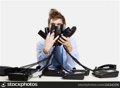 young man in the office and answering several phones at the same time