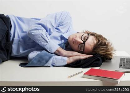 Young man in the office and sleeping over is desk