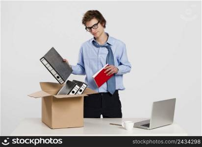 Young man in the office packing up after being fired