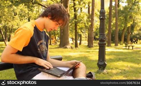 young man in the park using a laptop