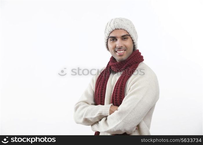 Young man in warm clothes standing over white background