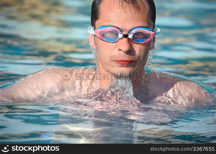 young man in watersport goggles swimming in pool