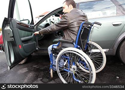 Young man in wheelchair getting in his car
