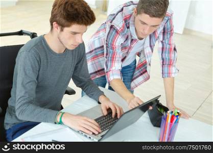 young man in wheelchair using laptop