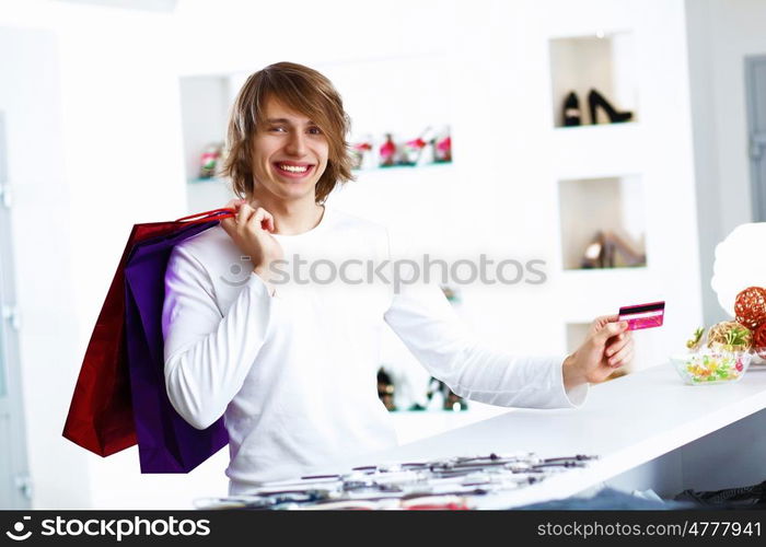 Young man in white sweater doing shopping