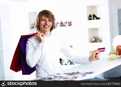 Young man in white sweater doing shopping