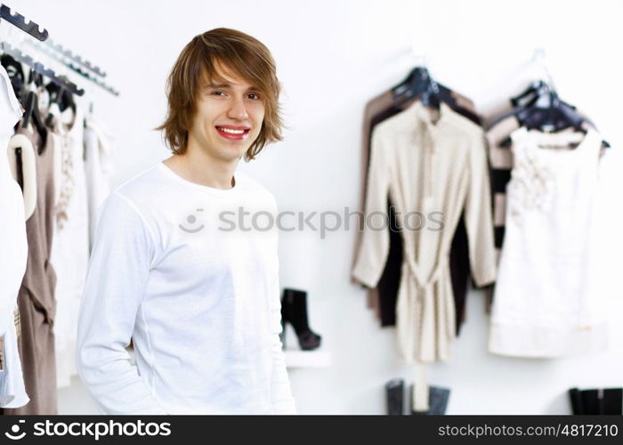 Young man in white sweater doing shopping