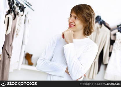 Young man in white sweater doing shopping