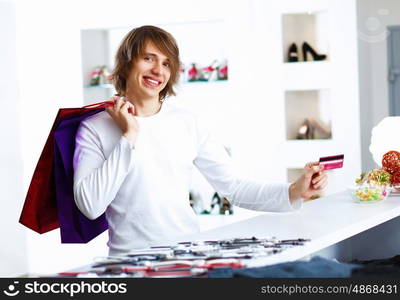 Young man in white sweater doing shopping