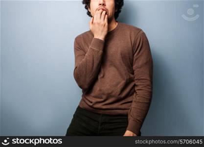 Young man is biting his nails