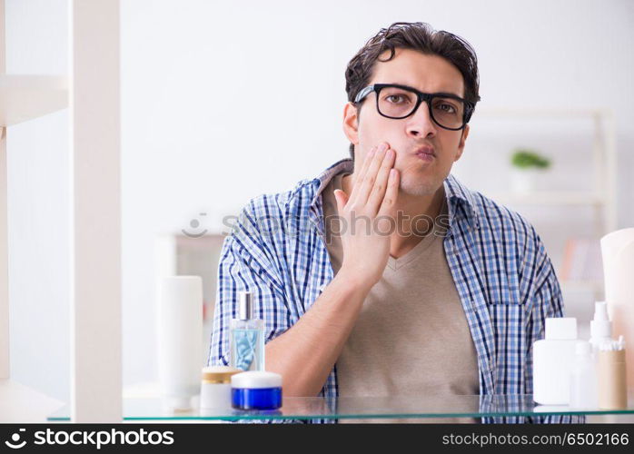 Young man is getting prepared for working day in bathroom