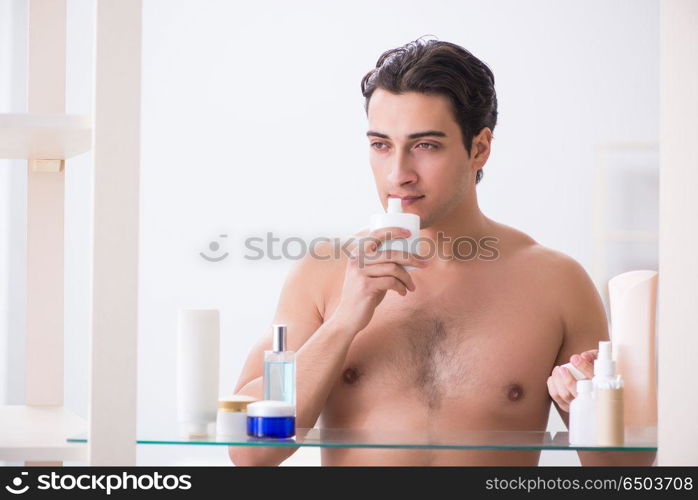 Young man is getting prepared for working day in bathroom