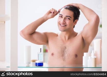 Young man is getting prepared for working day in bathroom