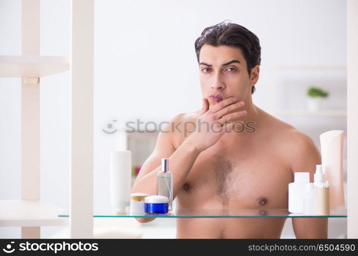 Young man is getting prepared for working day in bathroom