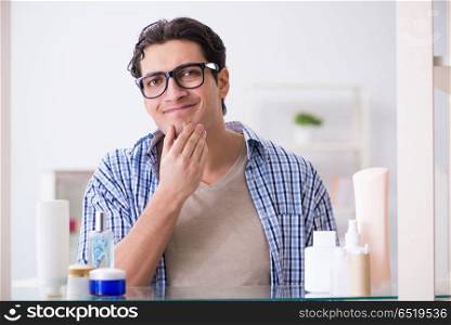 Young man is getting prepared for working day in bathroom