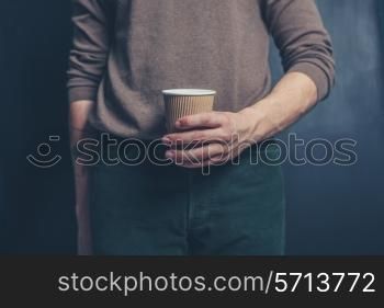 Young man is holding a brown paper cup
