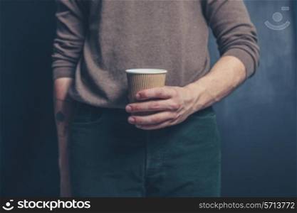 Young man is holding a brown paper cup