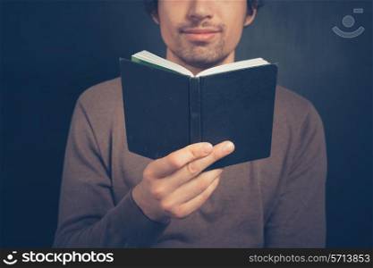 Young man is holding a notebook