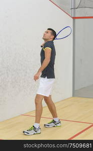 young man is playing tennis indoors