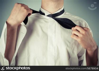 Young man is showing how to tie a formal bow tie