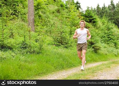 Young man jogging in nature in sportive outfit