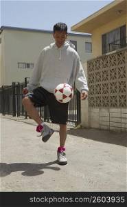 Young man juggling a soccer ball