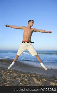Young man jumping at the blue beach