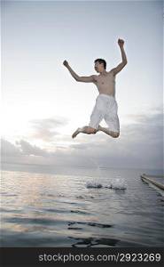 Young man jumping from water