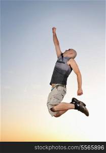 young man jumping in air at sunset outdoor