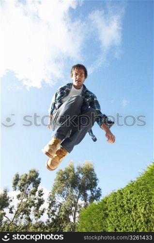 Young Man Jumping On Trampoline Caught In Mid Air