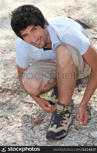 young man lacing his shoes