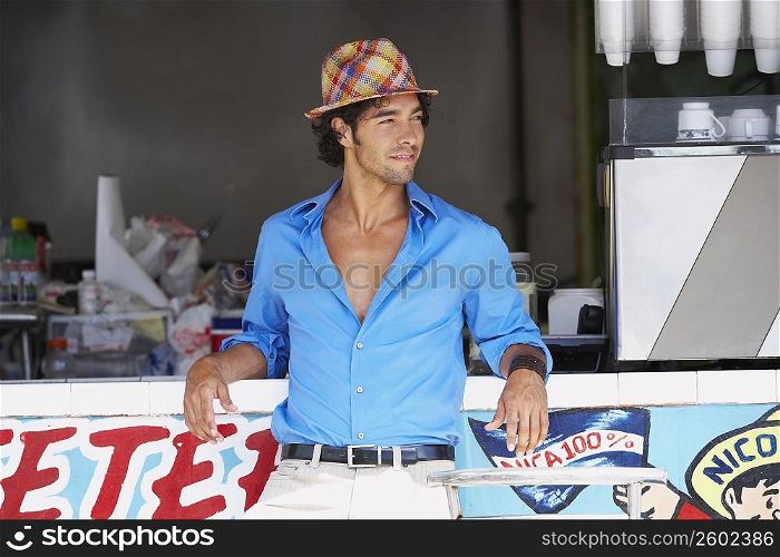 Young man leaning against a bar counter of a juice bar
