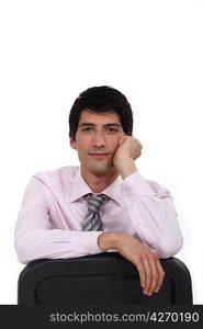 Young man leaning back in chair