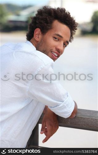 Young man leaning on a wooden fence