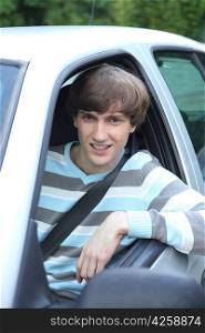 Young man leaning out of car window