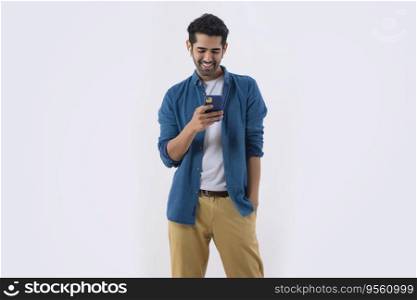 Young man listening music using earbuds and mobile with hand on pocket