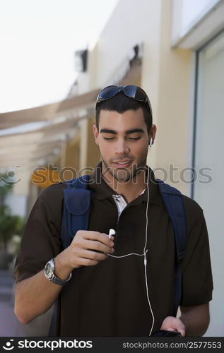 Young man listening to an MP3 player and smiling