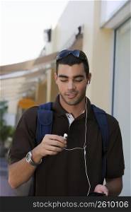Young man listening to an MP3 player and smiling