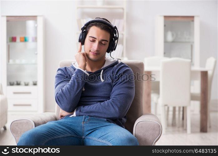 Young man listening to music at home