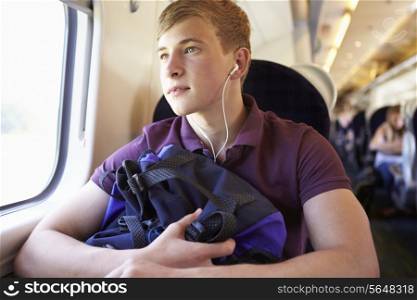Young Man Listening To Music On Train Journey