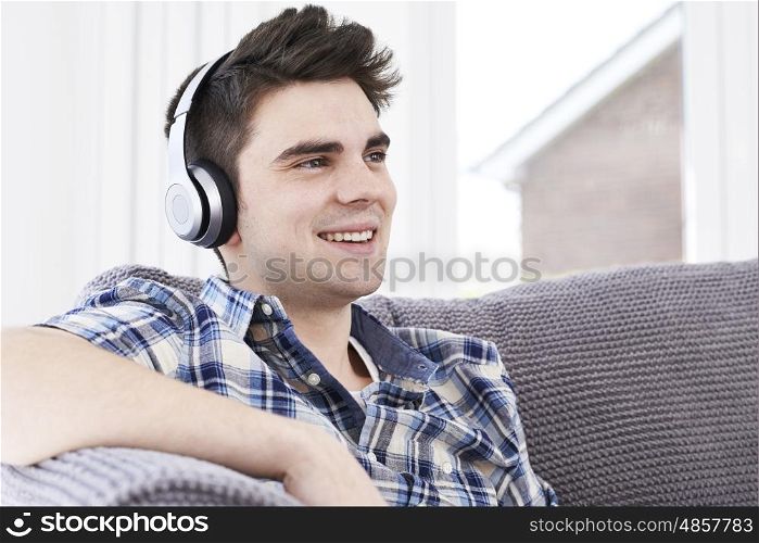 Young Man Listening To Music On Wireless Headphones