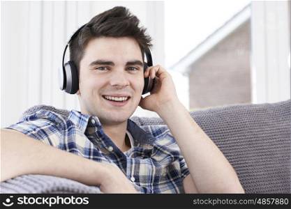 Young Man Listening To Music On Wireless Headphones