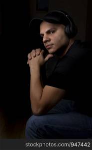 Young man listening to music with his headphones in the dark