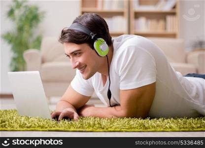 Young man listening to the music from laptop