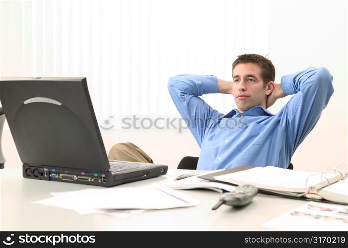 Young Man Looking at a Laptop in an Office