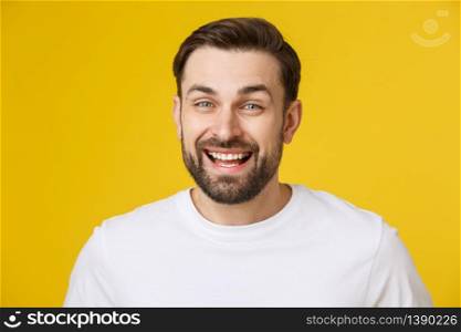 Young man looking at copyspace having a surprised or satisfied look isolated on yellow background. Young man looking at copyspace having a surprised or satisfied look isolated on yellow background.
